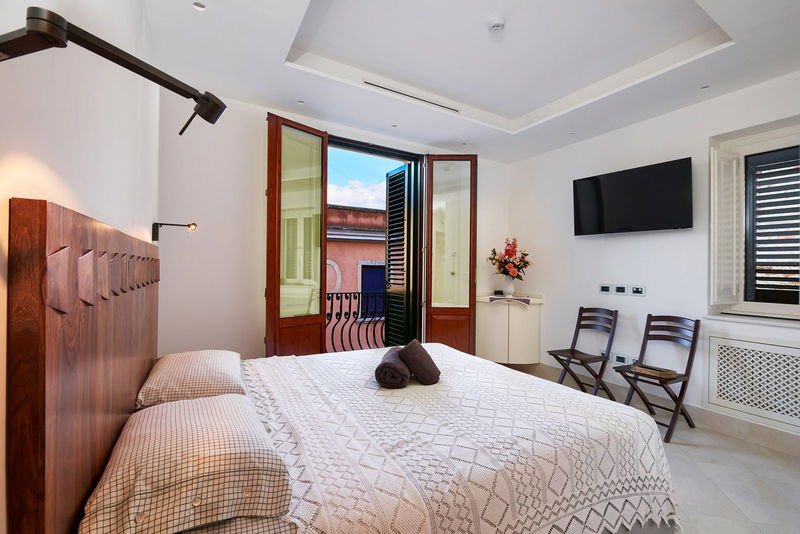 King Standard with the balcony doors open, television and folding chairs