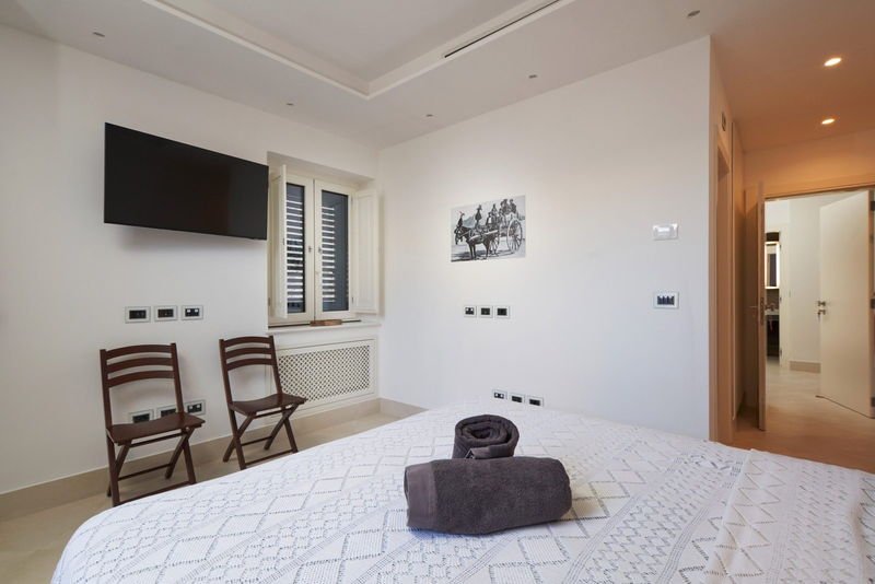 King Standard bedroom with a shuttered window and wall-mounted television