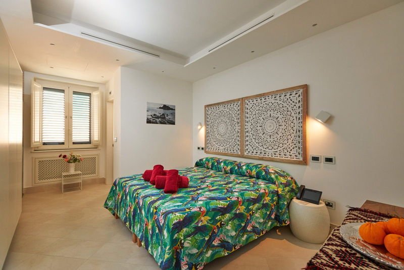King room with a carved panel headboard and printed bedspread