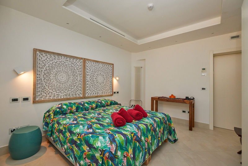 King room with carved panels above the bed and a printed bedspread