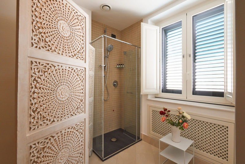 Shower enclosure beside a carved wooden screen