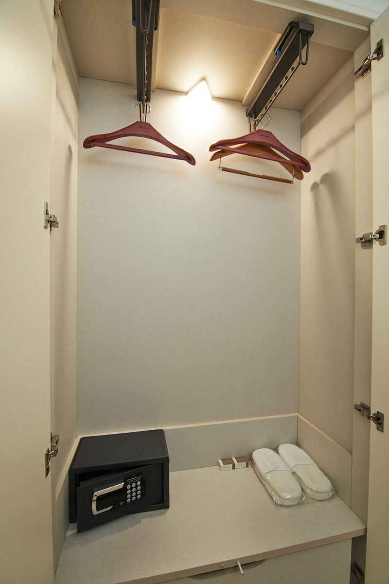 Walk-in wardrobe with hangers, safe and slippers